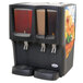 A black Crathco refrigerated beverage dispenser with two drinks in it.