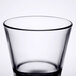 A close-up of a Libbey stackable rocks glass with a black rim.