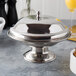 A stainless steel Town compote dish with a lid on a table.