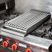 A metal grill on a stove top.
