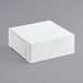 A white box with a lid on a gray surface.