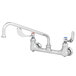 A chrome T&S wall mounted pantry faucet with wrist handles and a swing spout.