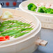 A Town bamboo steamer filled with broccoli and other vegetables.