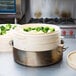 A Town bamboo steamer with broccoli and cauliflower in it.