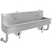 A stainless steel Advance Tabco multi-station hand sink with 2 knee operated faucets and hooks.