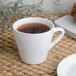 A Libbey Ultra Bright White porcelain espresso cup filled with coffee on a table.