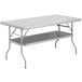 A grey rectangular Regency stainless steel folding work table with a shelf.