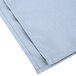 A pack of light blue Intedge cloth napkins with white stitching.