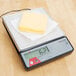 A Taylor digital portion scale with cheese on top.