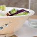 A Blue Bamboo melamine bowl filled with salad on a table.