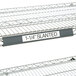 A gray Metro slanted plastic label holder on a shelf with labels.