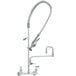 A T&S wall-mounted pre-rinse faucet with double-jointed add-on faucet and lever handles with a hose.