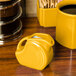 A yellow Fiesta mini disc creamer pitcher on a table.