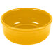 A yellow bowl with a handle on a white surface.