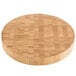 An American Metalcraft bamboo round cutting board on a table.