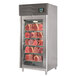 A stainless steel meat aging cabinet with meat on a shelf.