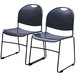 A pair of National Public Seating navy blue plastic stacking chairs with black metal legs.