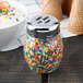 A Tablecraft slotted shaker top with sprinkles on a jar of ice cream.