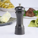A Chef Specialties gunmetal pepper mill on a table.