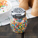 A Tablecraft chrome-plated plastic shaker with colorful sprinkles on top.
