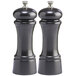 Two black pepper mills with silver caps.