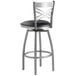 A Lancaster Table & Seating clear coat finish cross back swivel bar stool with black vinyl padded seat.
