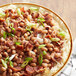 A bowl of black eye peas with rice and bacon.