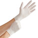 A pair of white, powder-free disposable latex gloves being worn on hands.