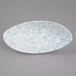 A white porcelain bowl with blue speckled design on the sides.
