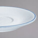 A 10 Strawberry Street Arctic Blue porcelain saucer with a blue rim.