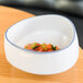 A 10 Strawberry Street Arctic Blue porcelain cereal bowl filled with food on a table.