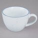 A white porcelain coffee cup with a blue rim.