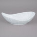 A white porcelain canoe bowl with blue speckled design.