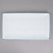 A white rectangular porcelain platter with blue specks on the surface.