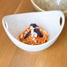 A blue and white porcelain bowl of pasta with red sauce and white cheese.