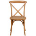 A Flash Furniture oak wood banquet chair with a cross back.