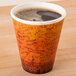 A Dart Fusion Escape foam coffee cup filled with coffee on a counter.