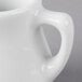 A close-up of a Tuxton white china creamer pourer.