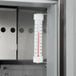 The interior of a Beverage-Air Elite Series refrigerator with a thermometer on a metal cabinet.