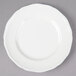 A Tuxton TuxTrendz Charleston white china bread and butter plate with a scalloped edge.