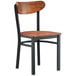 A Lancaster Table & Seating Boomerang Series chair with black metal legs and a wooden seat.