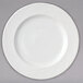 A white Arcoroc porcelain dinner plate with swirls in the design.