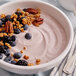 A bowl of Pequea Valley Farm blueberry yogurt with blueberries and nuts on a white plate.
