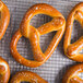 Several Dutch Country Foods soft pretzels on a cooling rack.