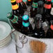 A Tablecraft stainless steel beverage tub filled with ice and beer bottles on a table.