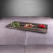 An Elite Global Solutions faux hickory wood melamine serving board with vegetables and herbs on it.