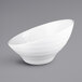 A white Elite Global Solutions Durango melamine bowl with a curved edge on a gray surface.