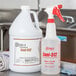 A white 32 oz. Labeled Bottle of Noble Chemical Sani-512 Food Surface Sanitizer on a counter in a professional kitchen.