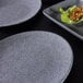 A close up of a Tenaya granite stone melamine plate with food on it.
