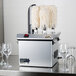 A silver Campus Products StemshinePro glass polisher machine with white mops on top.